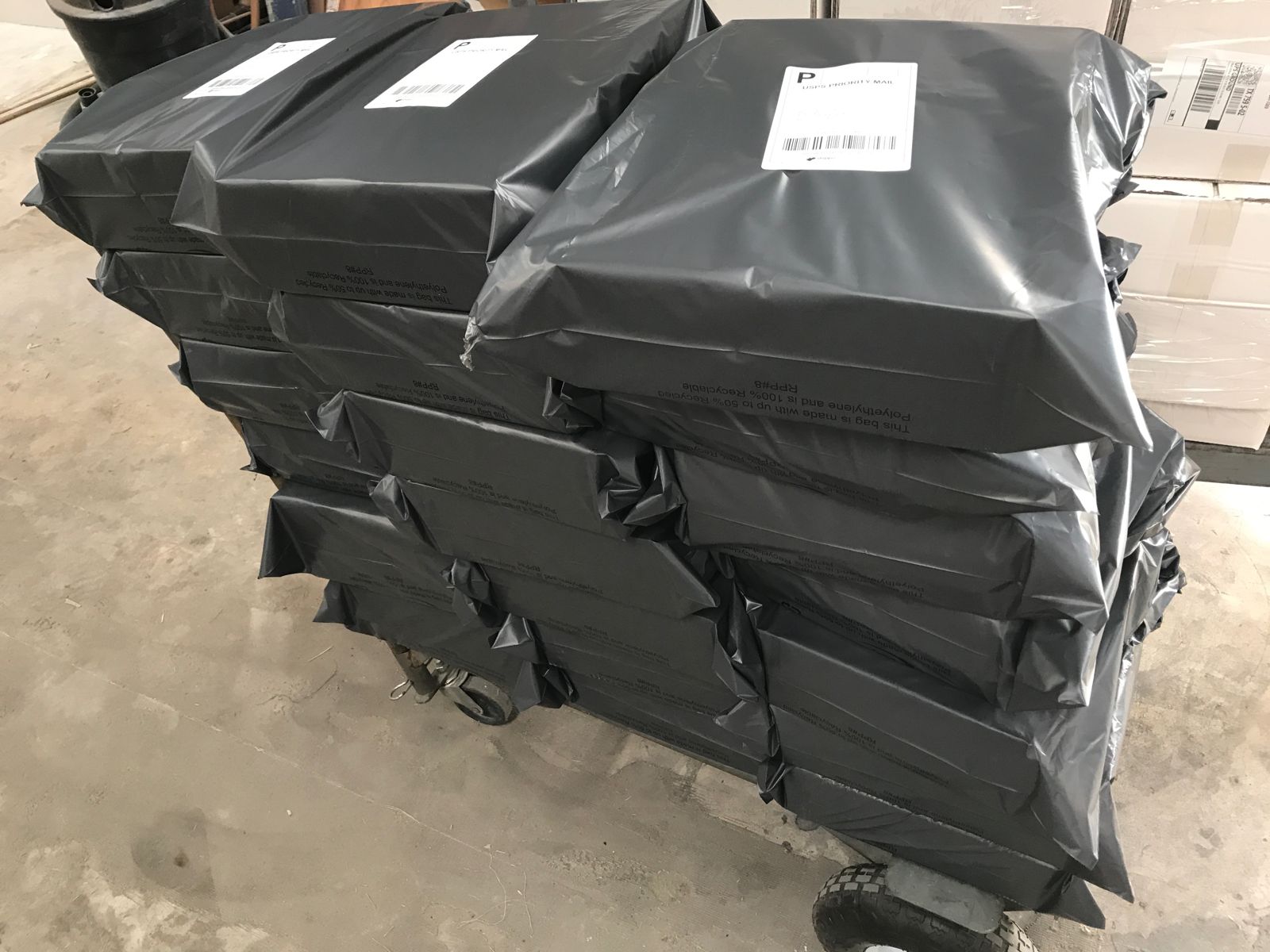 Stacks of poly-bagged direct-to-consumer orders labeled and ready to ship