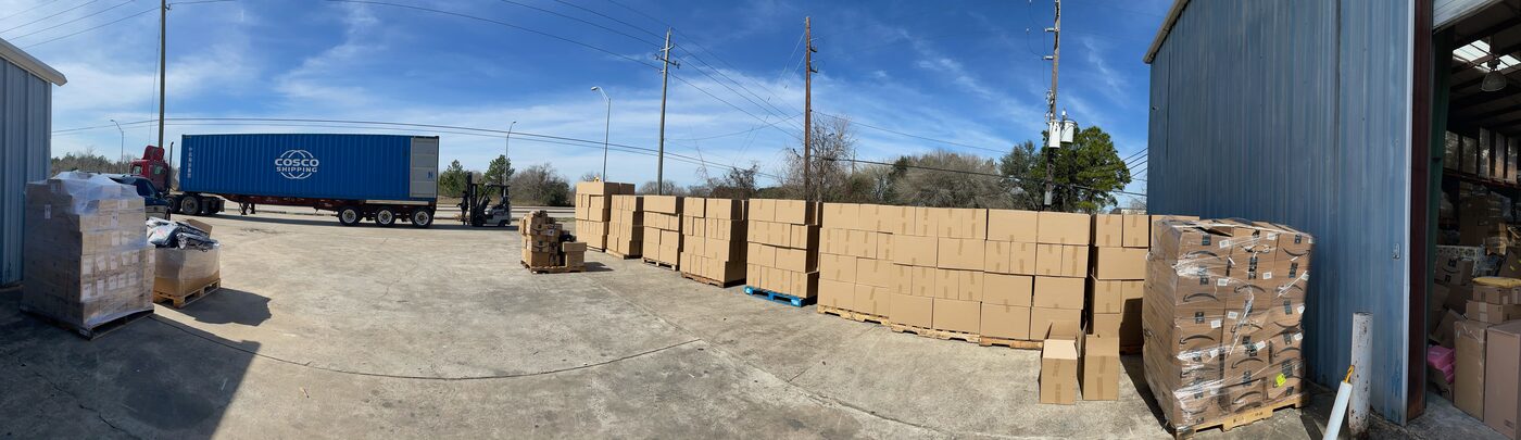 Palletized freight staged in FlexPrep's stabilized yard with container trailer